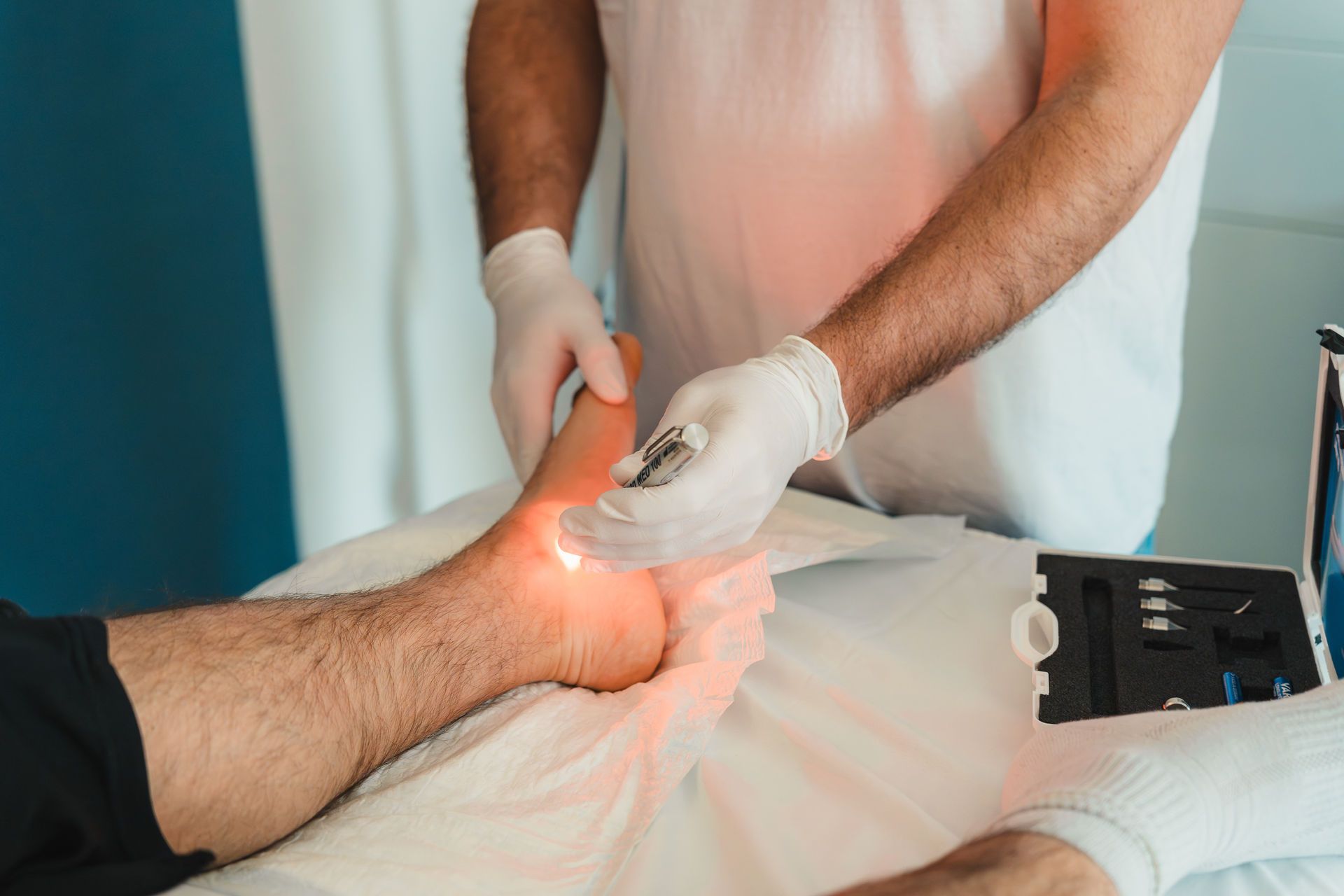 Low-Level Lasertherapie (LLLT) durch DGKP Christian Erber am Fuß eines Patienten