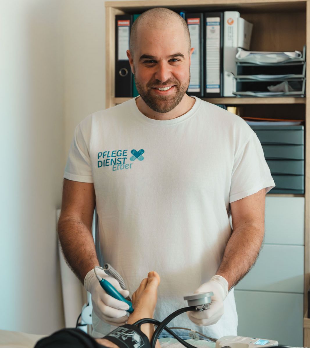 DGKP Christian Erber misst den Blutdruck am Fuß eines Patienten