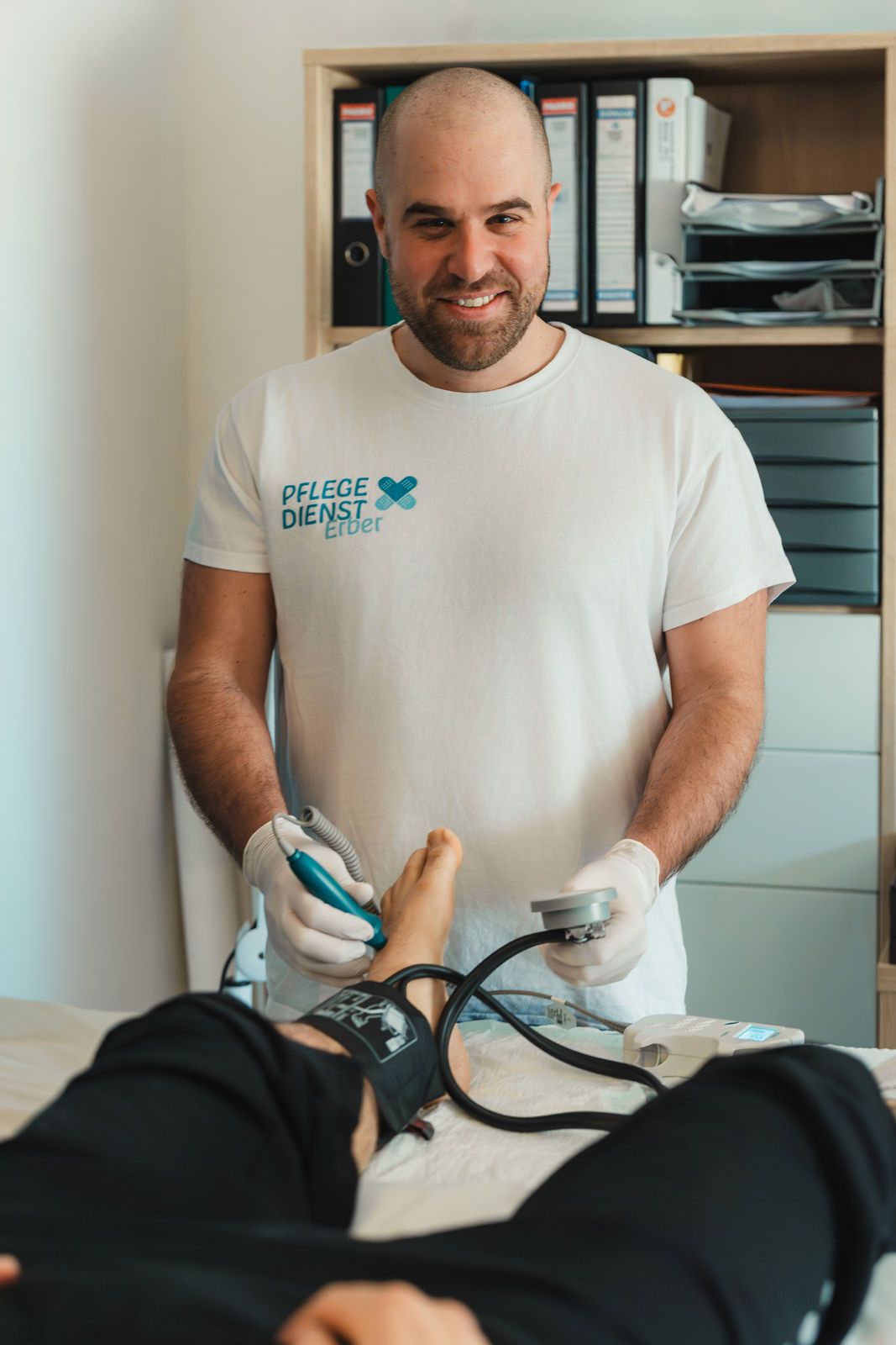 DGKP Christian Erber misst den Blutdruck am Fuß eines Patienten